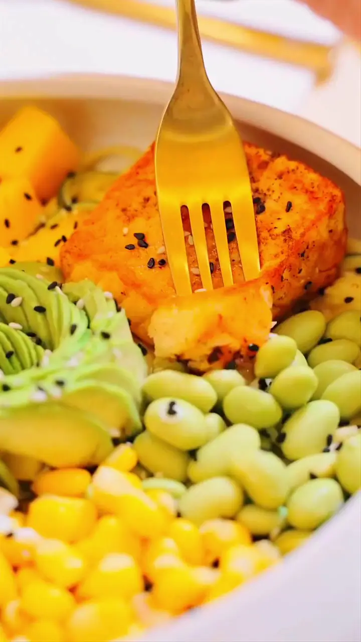 A colourful bowl with edamame, sweetcorn, avocado and a golden fork