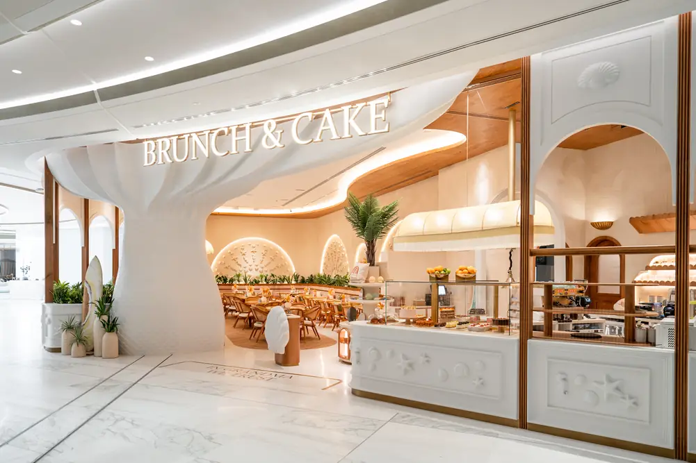The Brunch & Cake sign above the entrance, with the white olive tree and arched windows