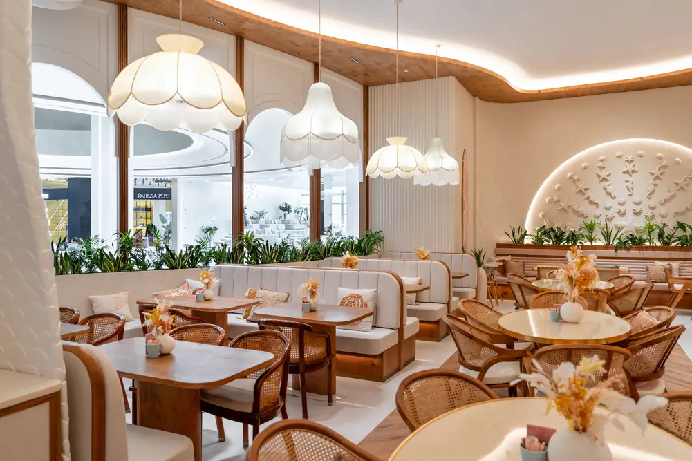 Long view of the dining room with rattan chairs and wooden ceiling