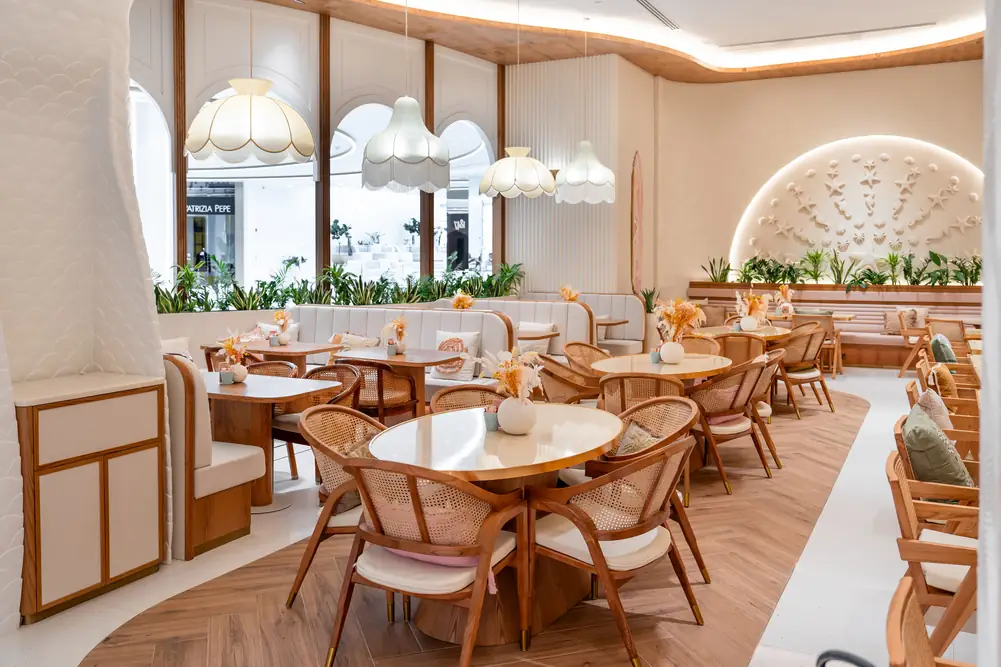 Bright seating area with soft sofas under fringed lamps
